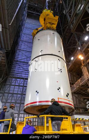 Dans High Bay 4 du Vehicle Assembly Building du Kennedy Space Center de la NASA en Floride, une grue abaisse des segments de lanceur de fusée solide du Space Launch System (SLS) sur une plate-forme lors d’un exercice d’entraînement le 8 janvier 2020. Une équipe d’ingénieurs d’exploration Ground Systems et d’opérateurs de grues et de techniciens avec l’entrepreneur Jacobs pratiquent des manœuvres de levage, de déplacement et d’empilage, en utilisant de l’équipement de soutien au sol important pour former les employés et certifier que tout l’équipement fonctionne correctement. Les détecteurs de trajectoire du booster sont des répliques inertes à grande échelle du matériel du booster qui le fera Banque D'Images