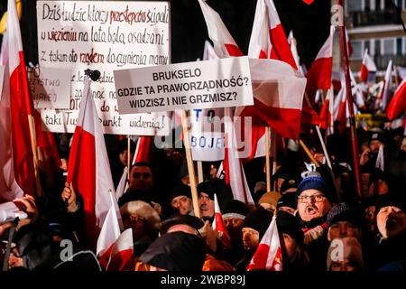 Les manifestants brandissent des drapeaux nationaux polonais et des pancartes pendant la manifestation. Protester contre les changements dans les médias publics en Pologne et dans la protection de la démocratie - disent les politiciens du pis. Le parti droit et Justice a régné en Pologne pendant 8 ans jusqu'à ce qu'ils perdent les dernières élections en octobre 2023. Le parti devient maintenant une force d'opposition de droite contre une coalition dirigeante plus centriste et libérale, dont la principale force politique est la Coalition civique dirigée par Donald Tusk, ancien président du Conseil de l'UE et aujourd'hui Premier ministre de Pologne. Banque D'Images