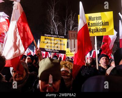 Les manifestants brandissent des drapeaux nationaux polonais et des pancartes pendant la manifestation. Protester contre les changements dans les médias publics en Pologne et dans la protection de la démocratie - disent les politiciens du pis. Le parti droit et Justice a régné en Pologne pendant 8 ans jusqu'à ce qu'ils perdent les dernières élections en octobre 2023. Le parti devient maintenant une force d'opposition de droite contre une coalition dirigeante plus centriste et libérale, dont la principale force politique est la Coalition civique dirigée par Donald Tusk, ancien président du Conseil de l'UE et aujourd'hui Premier ministre de Pologne. Banque D'Images