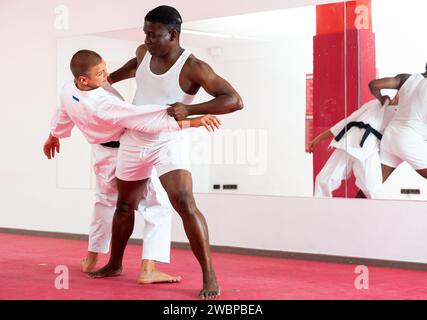 Deux hommes adault pratiquant des techniques d'autodéfense dans la salle de sport Banque D'Images
