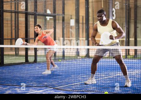 Équipe de padel joueurs homme et femme jouant doubles Banque D'Images