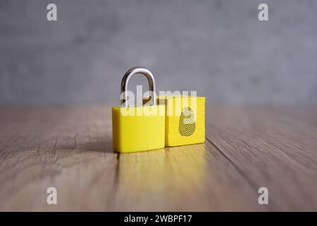 Cadenas et cube en bois avec icône d'empreinte digitale. Copier l'espace pour le texte. Concept de sécurité biométrique. Banque D'Images