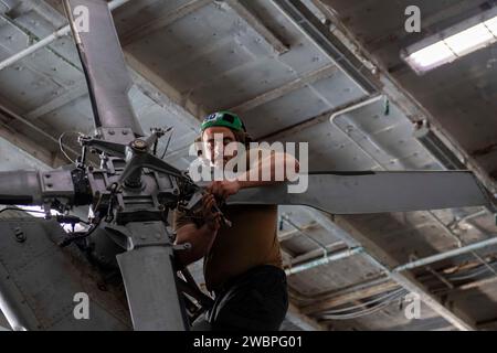 Kevin Lippincott, Machinin's Mate de 3e classe de l'US Navy Aviation, effectue la maintenance d'un hélicoptère MH-60S Sea Hawk, attaché aux « Dusty Dogs » de l'Helicopter Sea combat Squadron (HSC) 7, à bord du porte-avions USS Dwight D. Eisenhower (CVN 69) dans le golfe d'Oman le 23 novembre 2023. Le Dwight D. Eisenhower Carrier Strike Group est déployé dans la zone d'opérations de la 5e flotte américaine pour soutenir la sécurité maritime et la stabilité dans la région du Moyen-Orient. (Photo de l'US Navy par Nicholas Rodriguez, spécialiste des communications de masse) Banque D'Images