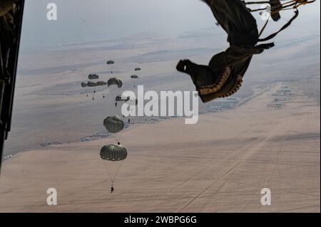 Les opérateurs des Forces spéciales interarmées qatariennes déploient leurs parachutes lors de l’opération Desert Redhawk 2 au-dessus d’un emplacement non divulgué dans la zone de responsabilité du commandement central des États-Unis le 25 décembre 2023. Plus de 50 opérateurs de la QJSF et parachutistes de l'armée américaine ont effectué une formation aérienne et aérienne dans le cadre de l'opération Desert Redhawk 2, leur permettant de maintenir leur état de préparation et leur expertise et de renforcer les relations entre les forces américaines et qatariennes. (Photo de l'US Air Force par le sergent d'état-major Caleb Roland) Banque D'Images