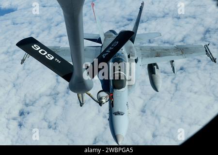 Un F/A-18 Hornet du corps des Marines des États-Unis est ravitaillé par un KC-135 Stratotanker de l'US Air Force depuis la base aérienne de Kadena au-dessus du Pacifique le 3 janvier 2024. Le 909e escadron de ravitaillement aérien mène des opérations conjointes dans toute la région Indo-Pacifique, démontrant le rôle crucial que jouent les forces de mobilité dans la projection de la force conjointe partout et à tout moment. (Photo de l'US Air Force par l'aviateur Cedriue Oldaker) Banque D'Images