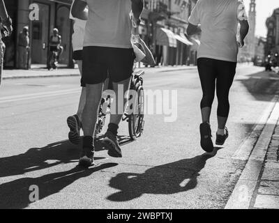 Athlètes Runners et Boy en fauteuil roulant pendant Sport Marathon. Banque D'Images