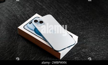 Jurmala, Lettonie - 09 01 2024 : gros plan du nouveau smartphone Apple iPhone 15 plus en couleur bleue et boîte blanche. Banque D'Images