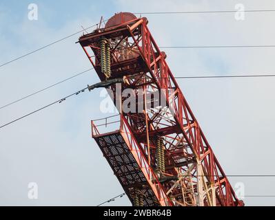 Fragment d'un énorme mât de ligne de transmission d'énergie avec des fils et des isolants contre le ciel Banque D'Images