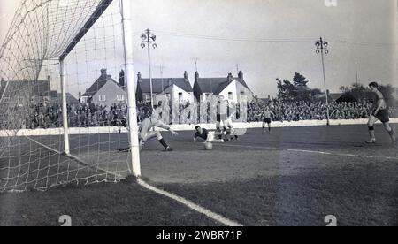 1960, historique, match de football, gardien de but en casquette essayant de saisir le ballon dans le match d'Oxford United contre Chelmsford City au Manor Ground, Oxford, Angleterre. Formé sous le nom de Headington F. C en 1893, ils sont devenus Headington United en 1911, puis Oxford United en 1960 lorsqu'ils étaient en première division de la Southern League, qu'ils ont remporté deux saisons consécutives. En 1962, ils sont élus (promus) en quatrième division de la Ligue de football après qu'Accrington Stanley ait quitté leur poste. Banque D'Images