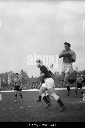 1960, match de football historique, gardien de but sautant dans les airs tenant le ballon au match entre Oxford United et Chelmsford City au Manor Ground, Oxford, Angleterre. Formé sous le nom de Headington F. C en 1893, le club devient Headington United en 1911, puis Oxford United en 1960 lorsqu'ils sont en première division de la Southern League, qu'ils remportent deux saisons de suite. En 1962, ils sont élus (promus) en quatrième division de la Ligue de football après qu'Accrington Stanley ait quitté leur poste. Banque D'Images