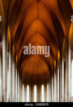 Angle bas de l'intérieur géométrique avec plafond en dôme et fenêtres étroites à l'intérieur de l'église Hallgrimskirkja à Reykjavik Banque D'Images