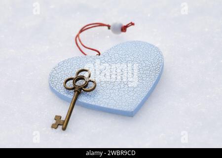 Jouet coeur et clé sur la neige, concept sur le thème de l'amour non partagé ou métaphore de la clé du cœur, fond pour la Saint Valentin Banque D'Images