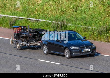 Moteur ferroviaire miniature et chariot. Moteur à vapeur Florence & Cripple Creek No.7 remorqué de calibre 7,25', chemin de fer à voie étroite transporté sur l'autoroute M6 Royaume-Uni par 2010 BMW 318D es Black car Estate Diesel 1995 cc Banque D'Images