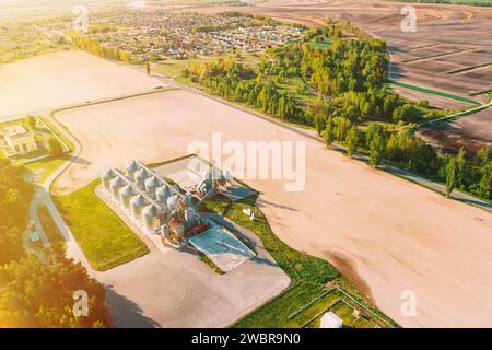 Vue aérienne en hauteur en haut Granary moderne, complexe de séchage de grain, silos commerciaux ou de graines dans le paysage rural de Sunny Spring.Silos de dessiccateur de maïs Banque D'Images