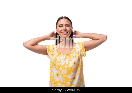 femme brune confiante européenne avec les cheveux lâches portant un t-shirt jaune sur un fond blanc avec espace copie Banque D'Images