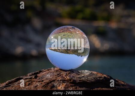 Boule de verre couchée sur une borne rouillée, journée ensoleillée en automne à Cres (Croatie) Banque D'Images