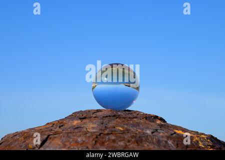 Boule de verre couchée sur une borne rouillée, journée ensoleillée en automne à Cres (Croatie), ciel bleu Banque D'Images