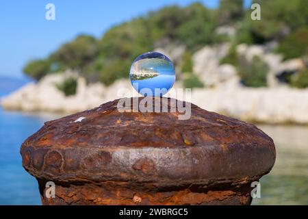 Boule de verre couchée sur une borne rouillée, journée ensoleillée en automne à Cres (Croatie) Banque D'Images