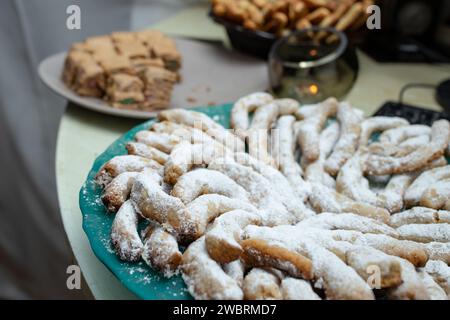 Biscuits sablés en forme de demi-lune saupoudrés de sucre en poudre, sur une assiette verte, Soft Focus Banque D'Images