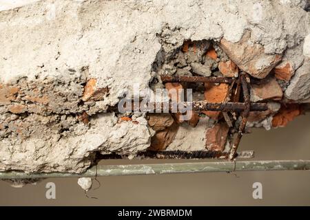 Démolition d'un mur de briques avec des tiges de fer rouillées, textures abstraites Banque D'Images