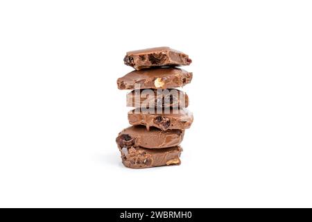 Pile de morceaux de chocolat avec raisins secs et cacahuètes, isolé sur blanc Banque D'Images