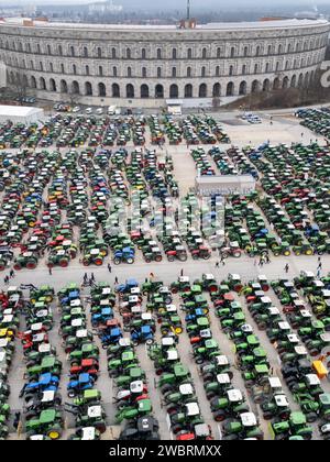 Nuremberg, Allemagne. 12 janvier 2024. De nombreux tracteurs sont garés lors d'un rassemblement d'associations d'agriculteurs contre les plans d'austérité du gouvernement fédéral à la Volksfestplatz (vue aérienne avec un drone). Le rassemblement fait partie d'actions de protestation nationales et est dirigé contre les coupes du gouvernement fédéral dans le diesel agricole et les véhicules agricoles. Crédit : Daniel Karmann/dpa/Alamy Live News Banque D'Images