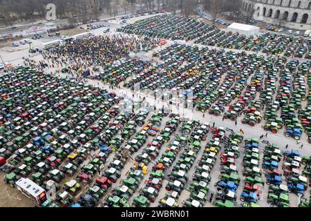 Nuremberg, Allemagne. 12 janvier 2024. De nombreux tracteurs sont garés lors d'un rassemblement d'associations d'agriculteurs contre les plans d'austérité du gouvernement fédéral à la Volksfestplatz (vue aérienne avec un drone). Le rassemblement fait partie d'actions de protestation nationales et est dirigé contre les coupes du gouvernement fédéral dans le diesel agricole et les véhicules agricoles. Crédit : Daniel Karmann/dpa/Alamy Live News Banque D'Images