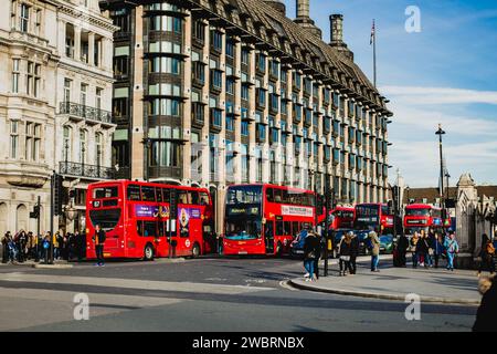 Cinq bus urbains rouges circulent les uns après les autres dans les rues de Londres. Banque D'Images