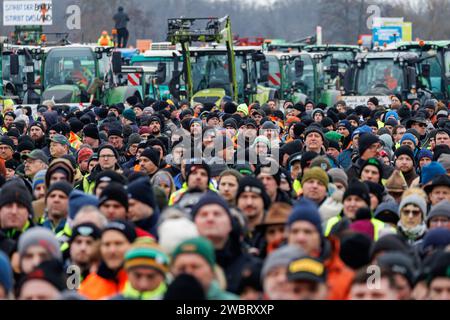 Nuremberg, Allemagne. 12 janvier 2024. De nombreux agriculteurs participent à un rassemblement d'associations d'agriculteurs contre les plans d'austérité du gouvernement fédéral. Le rassemblement fait partie d'actions de protestation nationales et vise à lutter contre la réduction des avantages fédéraux pour le diesel agricole et les véhicules agricoles. Crédit : Daniel Karmann/dpa/Alamy Live News Banque D'Images