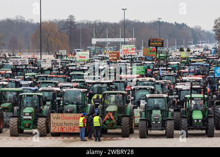 Nuremberg, Allemagne. 12 janvier 2024. De nombreux tracteurs sont garés sur la Volksfestplatz lors d'un rassemblement d'associations d'agriculteurs contre les plans d'austérité du gouvernement fédéral. Le rassemblement fait partie d'actions de protestation nationales et est dirigé contre la réduction des allocations fédérales pour le diesel agricole et les véhicules agricoles. Crédit : Daniel Karmann/dpa/Alamy Live News Banque D'Images