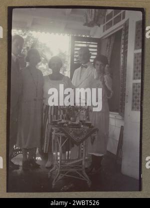 Compagnie sur une véranda, peut-être au Suriname, c. 1920 - c. 1930 photographie partie d'un album photo d'une famille néerlandaise inconnue avec des enregistrements du Suriname, de l'Europe et des Indes orientales néerlandaises. Suriname (peut-être) support photographique homme adulte. femme adulte. Oiseaux domestiques (à l'intérieur de la maison) Suriname Banque D'Images