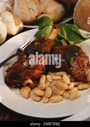 cuisses de canard cuites servies avec des herbes et de la sauce et des amandes - vue de côté Banque D'Images