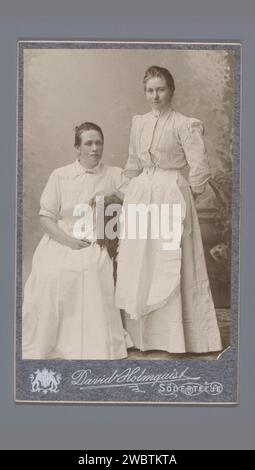 Portrait de deux femmes inconnues avec tabliers, David Holmqvist, 1904 - 1910 Photographie. Visitez la carte Södertälje support photographique. carton adolescent, jeune femme, jeune fille (+ deux personnes). Personnes historiques anonymes dépeintes dans un double portrait - BB - femme Banque D'Images