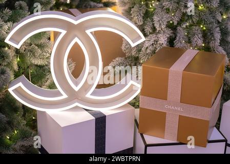 Modèle lumineux de logo Chanel & boîte cadeau avec ruban avec inscription Chanel avec sapin de Noël le 17 décembre 2023, à Bangkok, Thaïlande Banque D'Images