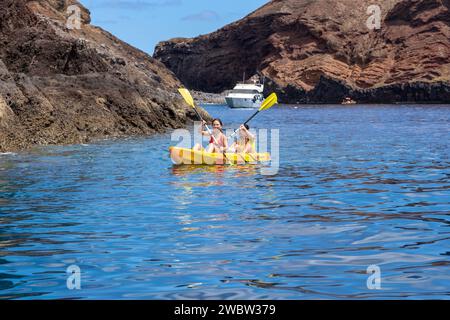 ÎLE DE MADÈRE, PORTUGAL - 28 AOÛT 2021 : des jeunes femmes non identifiées font du kayak au large des côtes rocheuses de l'île. Banque D'Images