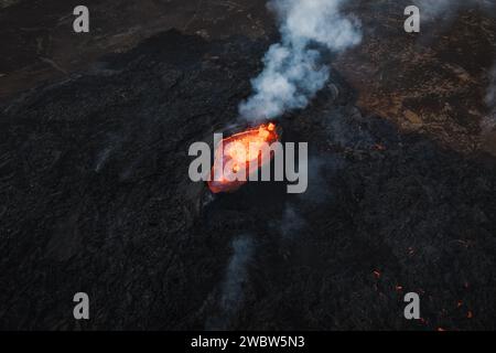 Vue unique sur le volcan en éruption et ses environs, lave rouge bouillante coulant, tir de drone. Catastrophes naturelles, environnement et climat Banque D'Images