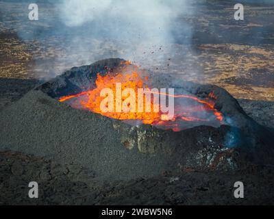 Vue unique sur le volcan en éruption et ses environs, lave rouge bouillante coulant, tir de drone. Catastrophes naturelles, environnement et climat Banque D'Images