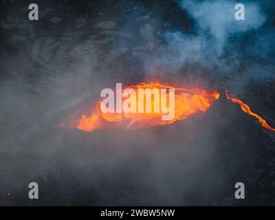 Vue unique sur le volcan en éruption et ses environs, lave rouge bouillante coulant, tir de drone. Catastrophes naturelles, environnement et climat Banque D'Images