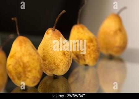 Vue rapprochée des poires sur une table en verre avec des reflets Banque D'Images