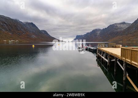 Panorama avec bateau sur le fjord, entre montagnes escarpées, village sur la rive de l'Atlantique Nord. hangar à bateaux et maison de vacances en bois Banque D'Images