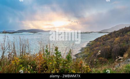 Un front de pluie s’approche de l’île de Sommarøy de l’autre côté de l’Atlantique. nuages colorés au coucher du soleil avec des nuages pluvieux roses et oranges, bleus et noirs Banque D'Images