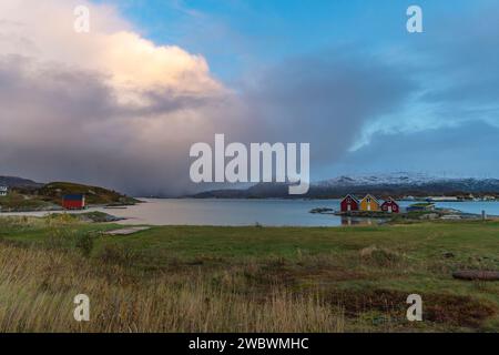 Un front de pluie s’approche de l’île de Sommarøy de l’autre côté de l’Atlantique. nuages colorés au coucher du soleil avec des nuages pluvieux roses et oranges, bleus et noirs Banque D'Images