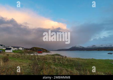 Un front de pluie s’approche de l’île de Sommarøy de l’autre côté de l’Atlantique. nuages colorés au coucher du soleil avec des nuages pluvieux roses et oranges, bleus et noirs Banque D'Images