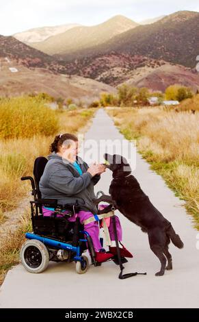 Femme utilise son fauteuil roulant électrique pour naviguer sur le chemin de randonnée dans la petite ville de montagne de Salida, Colorado, États-Unis Banque D'Images