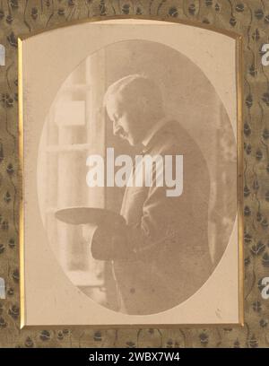 Portrait d'un homme avec une palette de peinture à la main devant une fenêtre, Anonyme, photographie 1850 - 1900. Cabinet photographie cette photo fait partie d'un album. carton. support photographique albumen estampe personnes historiques. portrait, autoportrait de peintre Banque D'Images