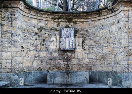 Lugano, Suisse - 14 janvier 2022 : l'ancienne fontaine sainte sur le côté de la célèbre cathédrale Saint-Laurent (construite en 818) à Lugano sur le Th Banque D'Images