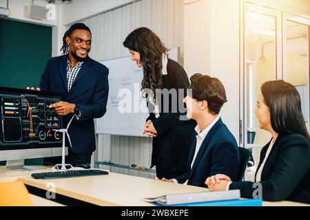 Dans un bureau moderne, divers collègues font preuve de travail d'équipe sur un projet de démarrage. Trois personnes Banque D'Images