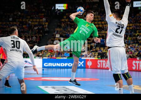 Munich, Allemagne. 12 janvier 2024. Handball : Championnat d'Europe, Hongrie - Monténégro, tour préliminaire, Groupe C, jour de match 1. Le Montenegro Vasilije Kaludjerovic prend un tir et le Hongrois Bence Banhidi en action. Crédit : Marco Wolf/dpa/Alamy Live News Banque D'Images