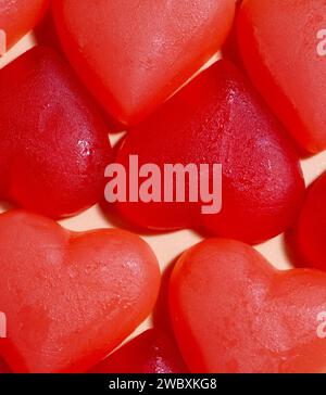 bonbons en forme de coeur rouge collés ensemble dans une grille, vue inclinée Banque D'Images