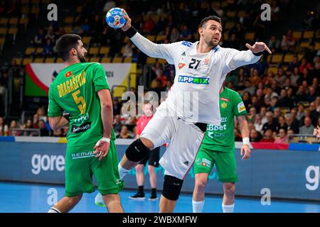 Munich, Allemagne. 12 janvier 2024. Handball : Championnat d'Europe, Hongrie - Monténégro, tour préliminaire, Groupe C, jour de match 1. Le Monténégro Arsenije Dragasevic (l) et le Hongrois Bence Banhidi en action. Crédit : Marco Wolf/dpa/Alamy Live News Banque D'Images